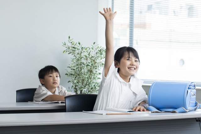 問題がわかって嬉しそうに手を挙げる小学生